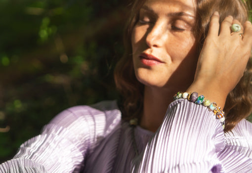 Glücksbringer Designerarmband auf einem Stein im Gras liegend