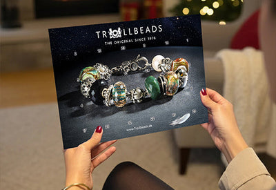 Model mit Adventskalender in gemütlichem Wohnzimmer mit Weihnachtsdeko