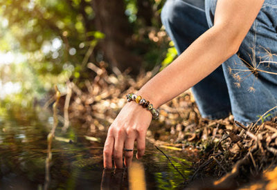 Modell beim Wandern am See im Wald mit von der Natur inspiriertem Schmuck