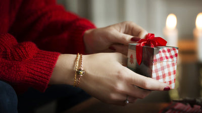 Ein Trollbeads-Weihnachtsgeschenk wird von einem Model mit goldenen Armspange geöffnet