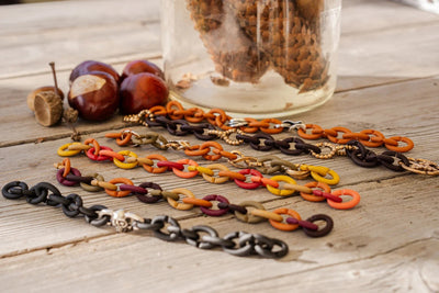 Armbänder von X Jewellery in Herbsttönen auf einem Holztisch