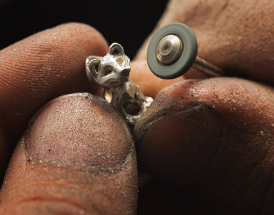 Frau spielt mit ihrem Hund in der Natur und trägt dabei Trollbeads-Schmuck aus der Pfötchenliebe Kollektion
