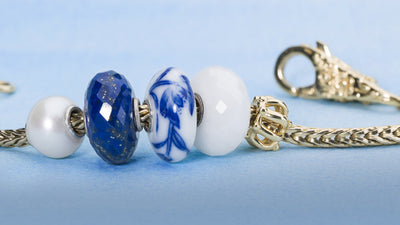 Gold chain with gold lock and a porcelain bead, a lapis lazuli bead, a white pearl bead and a white quartz bead