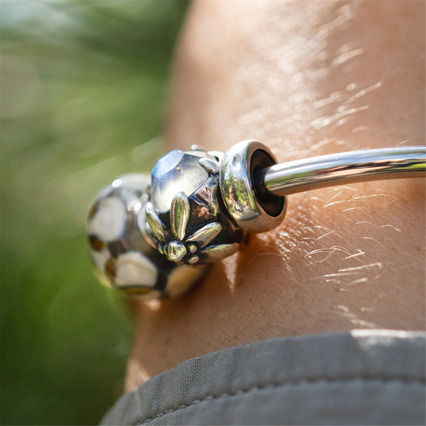 Alpenstern Edelweiß Silberbead mit facettiertem Labradorit an einer Armspange mit Silber Spacer und einem Glasbead am Handgelenk
