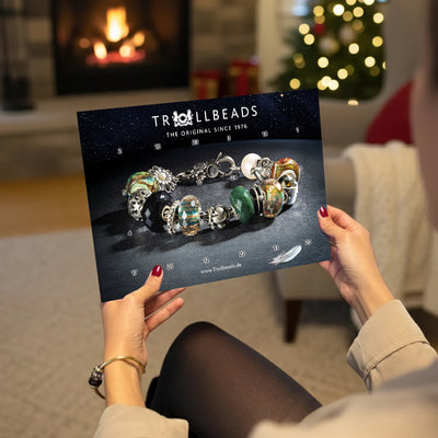 Model mit Adventskalender in den Händen in einem gemütlichen Weihnachtszimmer