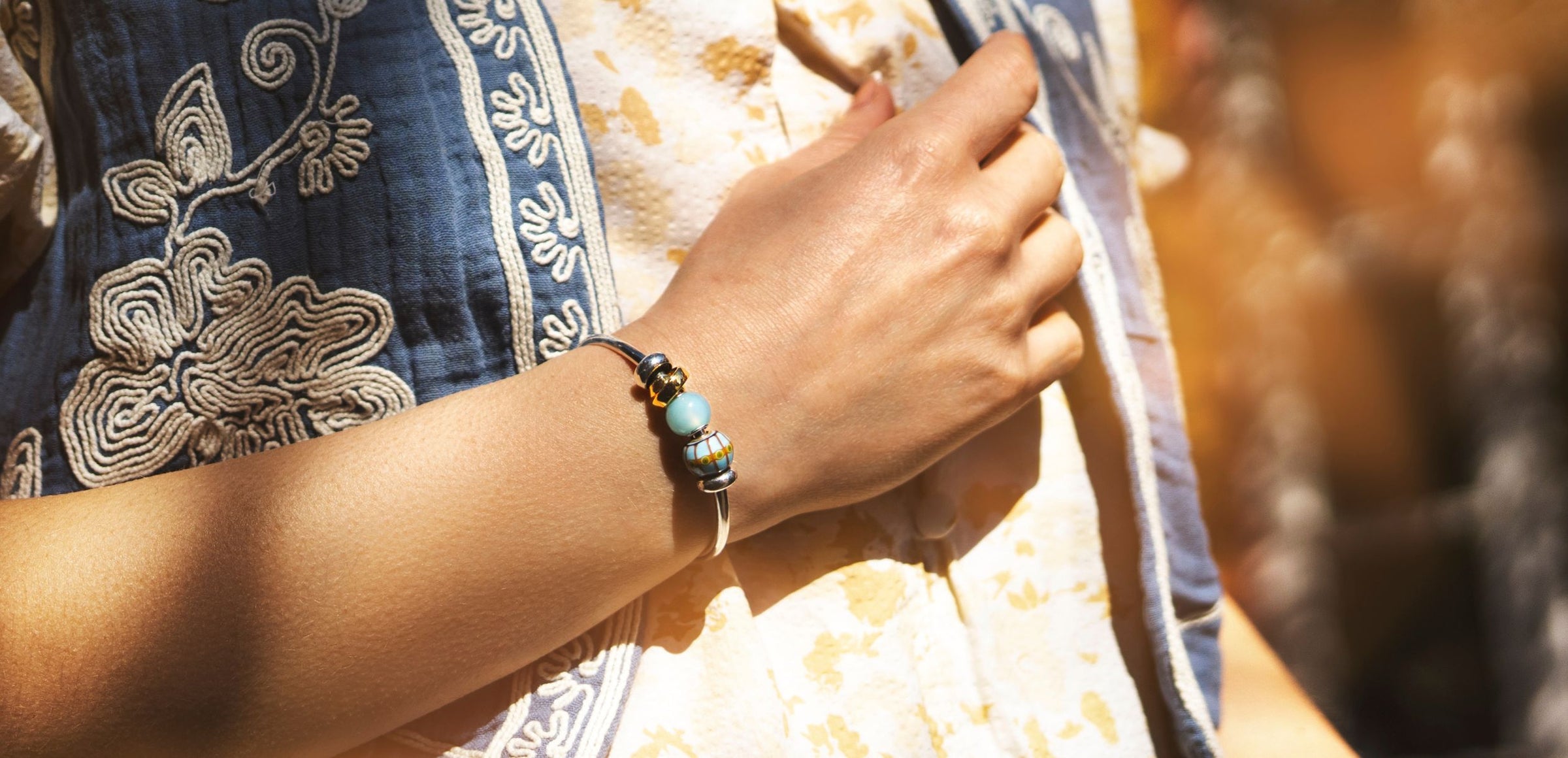 Frau trägt Trollbeads Day runde Beads an einer silbernen Armspange