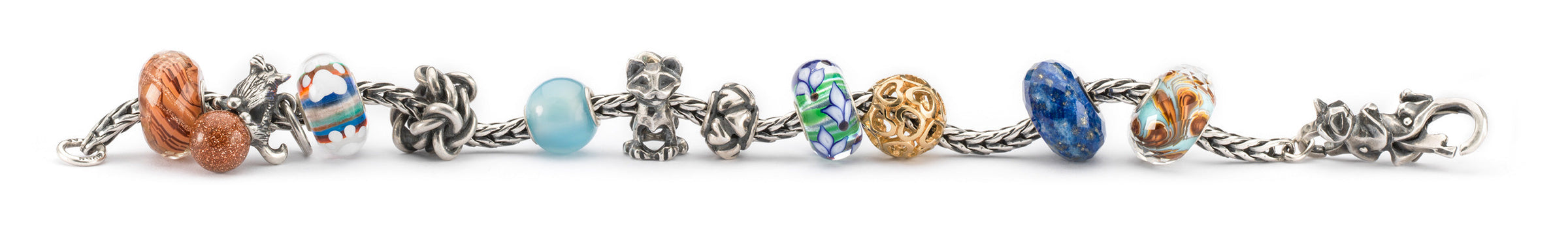 Trollbeads Armband mit einer Mischung aus Beads in Gold, Silber und Edelsteinen, ein Glasbeads mit einem kleinen Pfotenabdruck und Beads mit Katzen und einem Hund, die die geschätzte Bindung und Zuneigung zwischen Haustieren und ihren Besitzern darstellen.