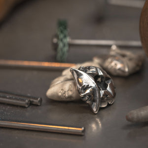 Magic Moon Silberbead auf einer Werkbank mit rohem Silberstangen und Werkzeugen