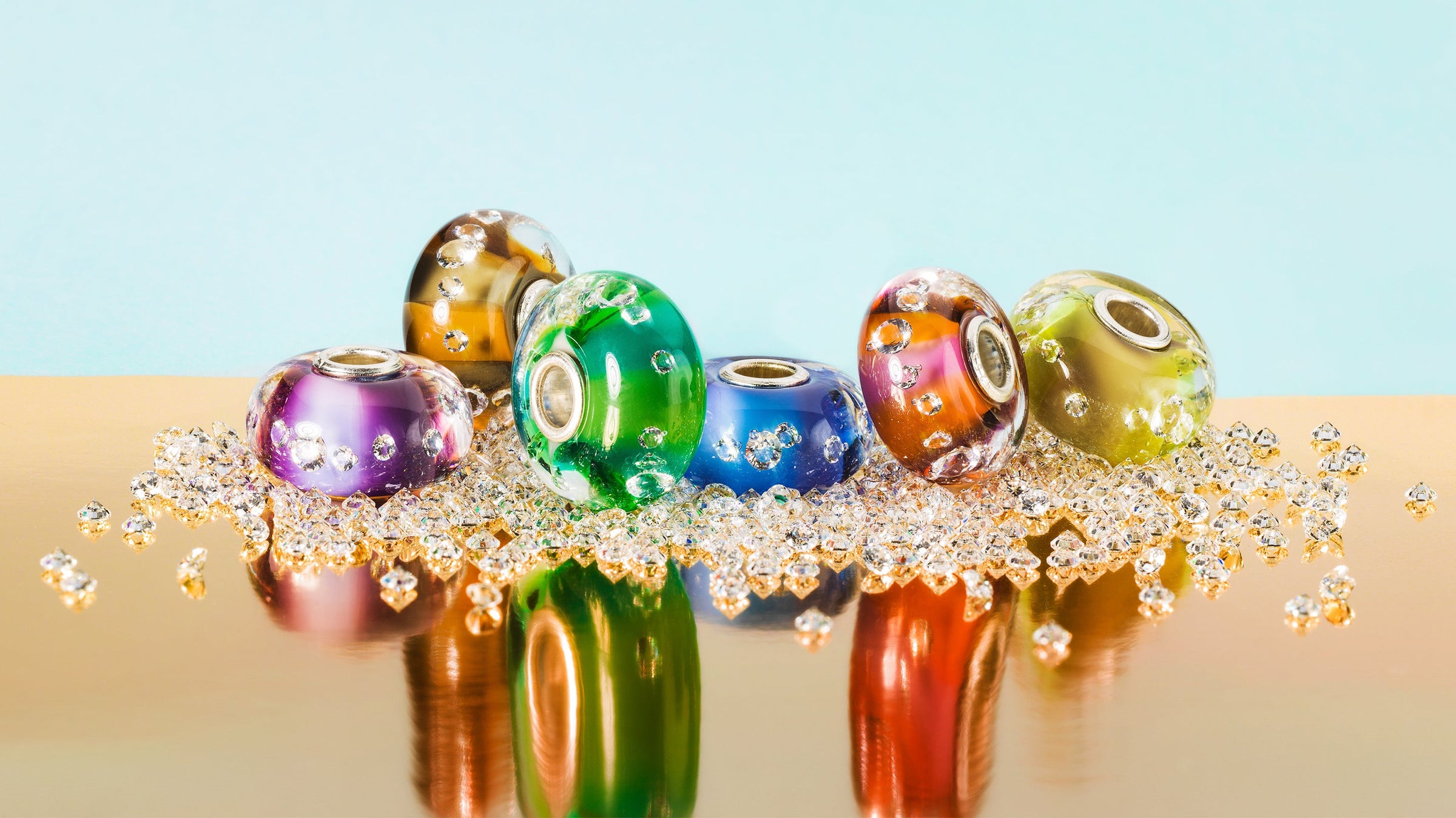 Die Kollektion enthält 6 Glasbeads. Alle Beads sind horizontal zweifarbig in knalligen Farben gehalten und enthalten 13 eingebettete Zirkonias