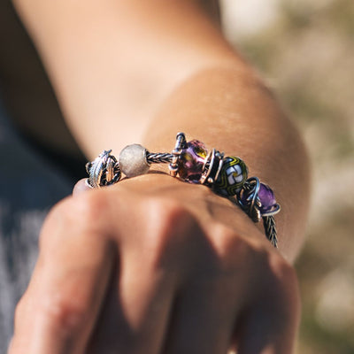 Model wearing a silver bracelet with different beads