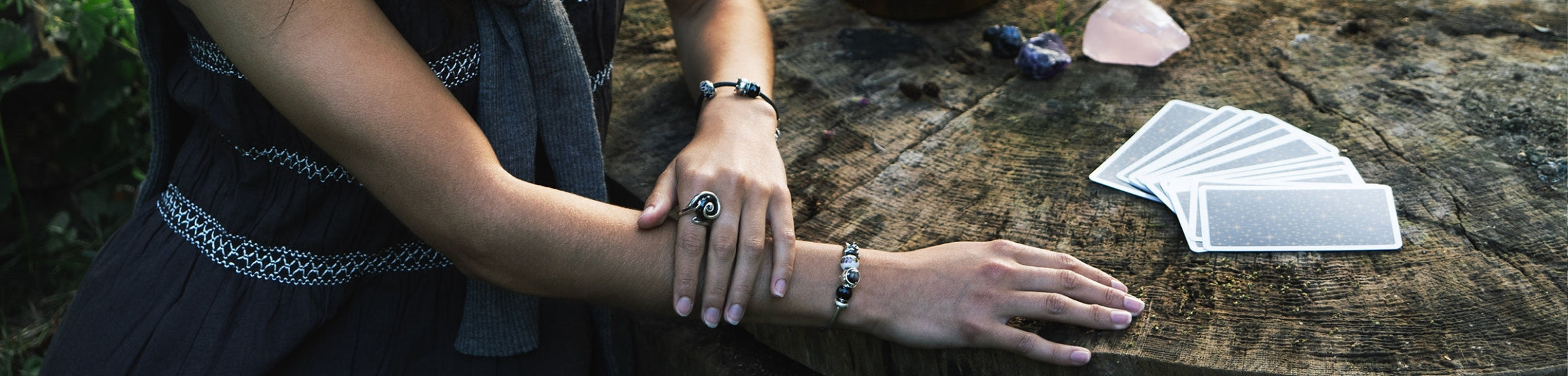 Model, das Armbänder mit Beads trägt, neben Tarotkarten