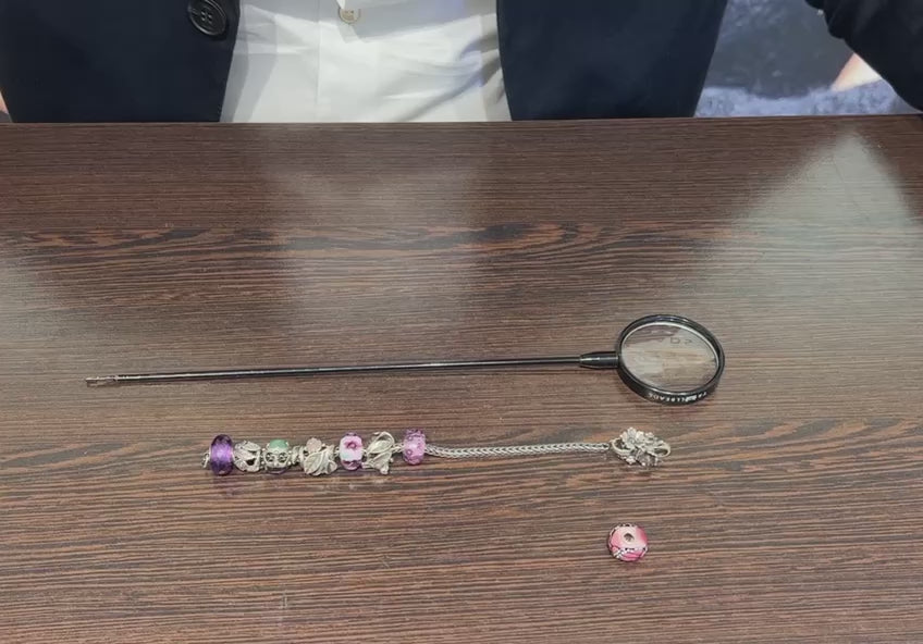 Fädelstange mit Lupe Vorführungsvideo. Beads eines Silberarmbandes werden auf die Stange gezogen und danach wieder zurück aufs Armband